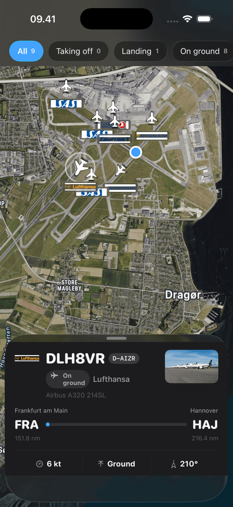 Zoomed in over Copenhagen Airport: aircraft on the stands and taxiways, each carrying its airline logo, with the runways visible underneath